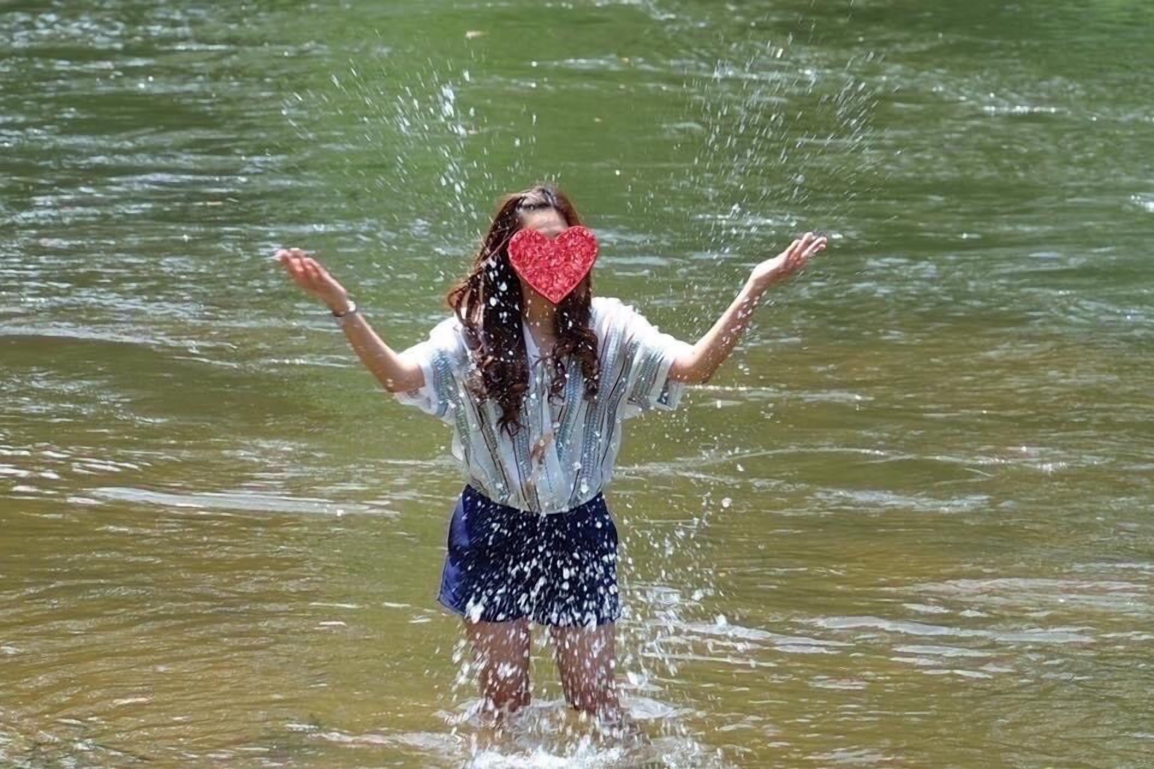 Una persona de pie en el agua con los brazos extendidos.