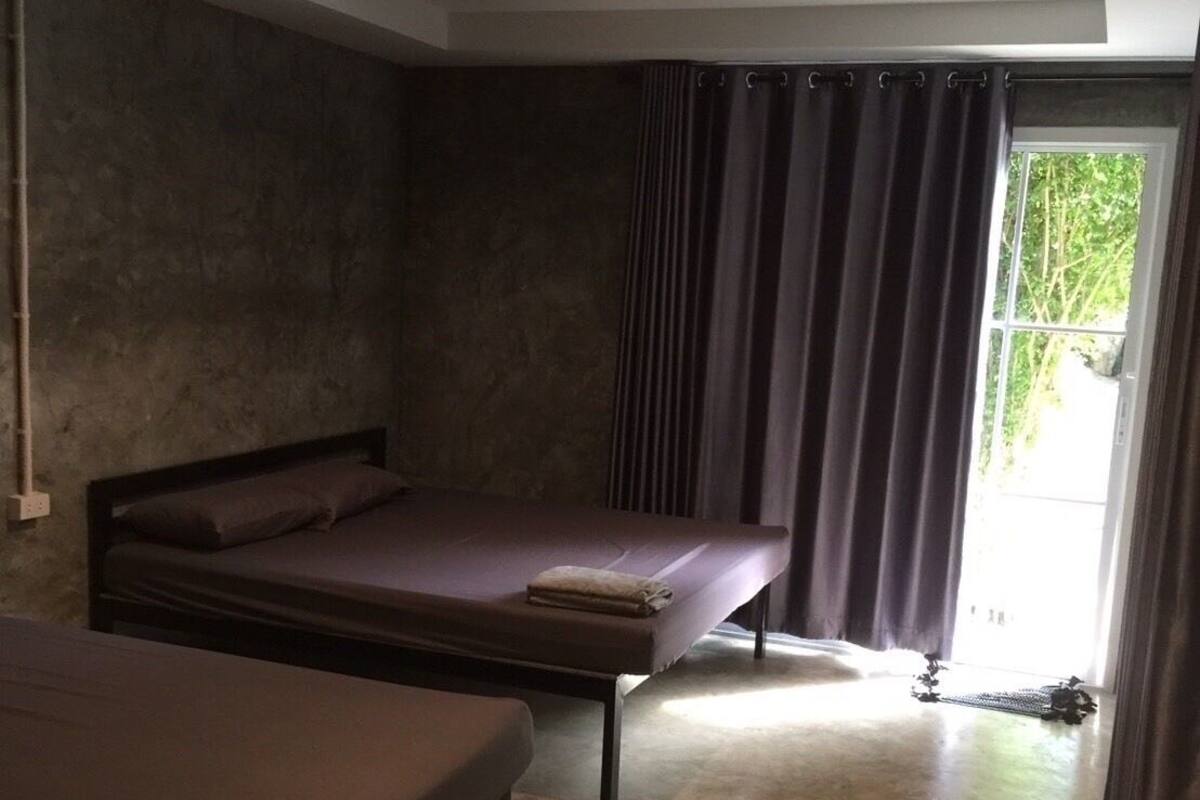Une chambre à coucher avec un lit, un banc et une fenêtre avec des rideaux.