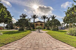 Stroll through lush gardens to the entrance of this serene building, flanked by palm trees and beautifully manicured grounds.
