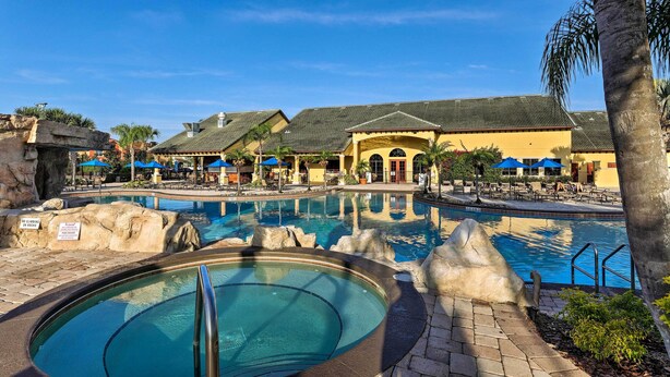 A resort pool area with a hot tub, lounge chairs, and umbrellas. - Paradise Palms Home w/ Pool, 6 Mi to Disney! (Kissimmee)