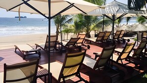 A beachside lounge area with sun loungers and umbrellas, overlooking the ocean. - 302 S Bay View Grand Residencial Ixtapa (Ixtapa)