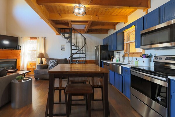 A modern kitchen with blue cabinets, a stainless steel oven, and a black microwave. - Almost Heaven - Minutes to the Parkway!! (Pigeon Forge)