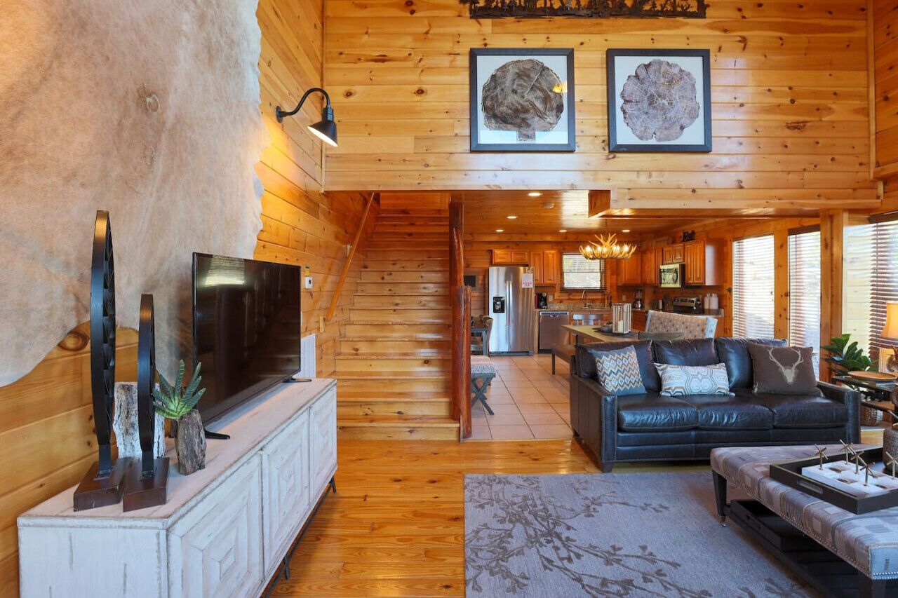 Ein rustikales Holzhaus-Interieur mit Wohnzimmer, Küche und Treppe.