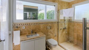 Ein Badezimmer mit Waschbecken, Toilette und Duschkabine.