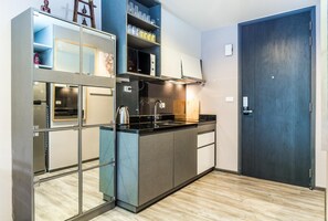 Kitchen features an oven, stainless steel range hood, and a small island with a sink and kettle.