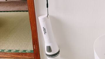 A white portable air purifier hanging on a wall near a mirror.