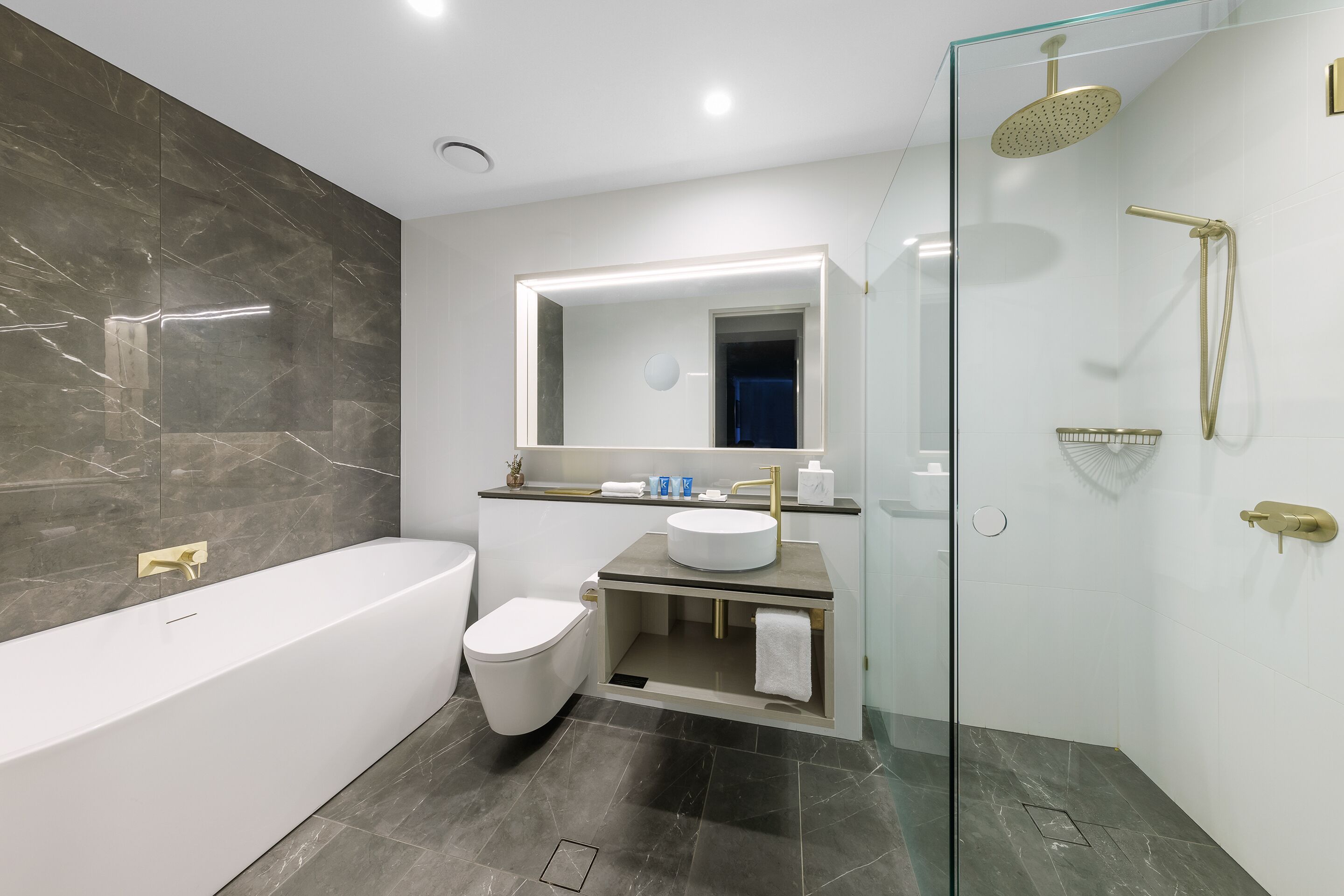 Une salle de bain moderne dotée d’une douche à parois de verre, d’une baignoire sur pieds et d’un meuble-lavabo avec un évier et un miroir.