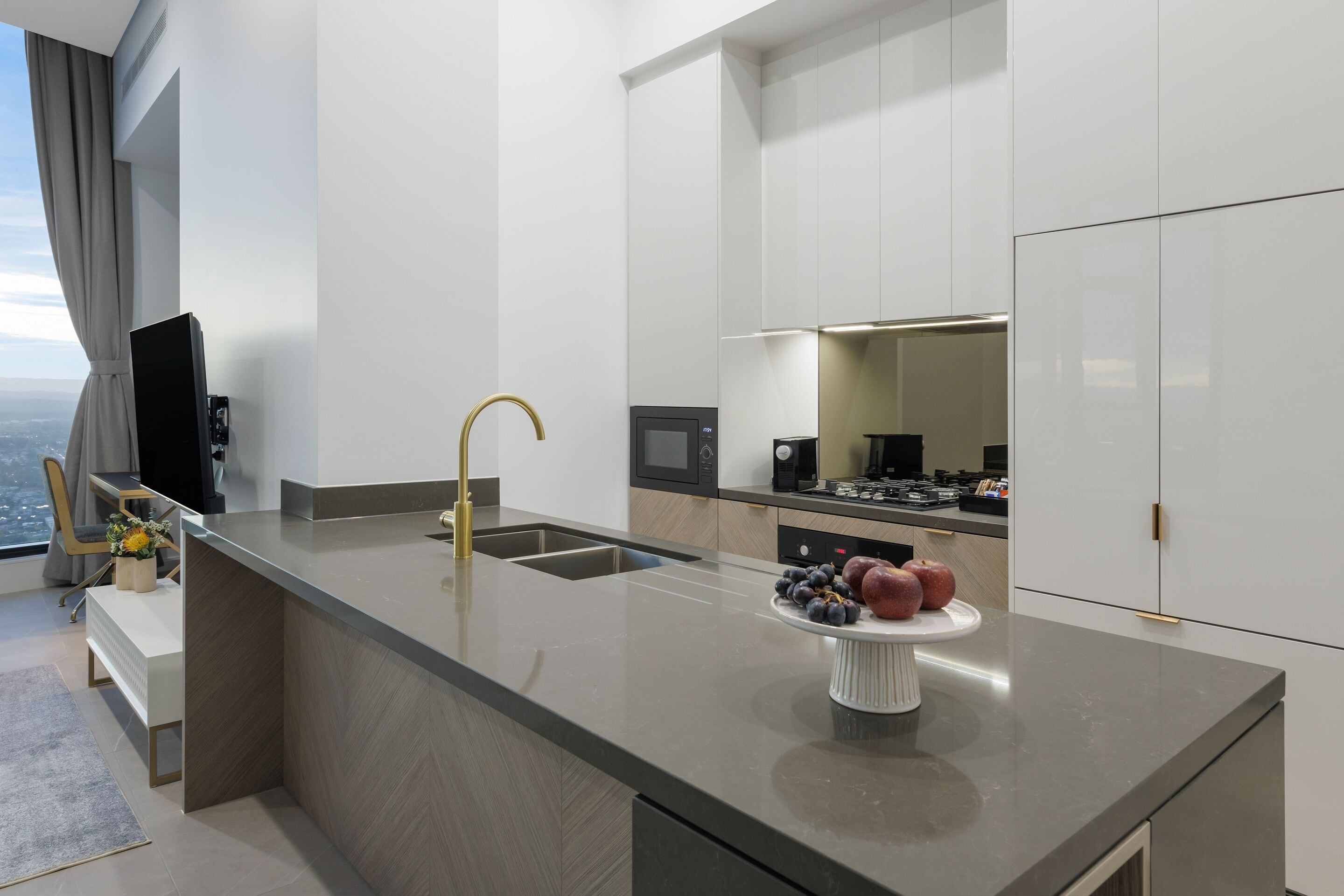 A modern kitchen with a central island, stainless steel appliances, and a view of the city.