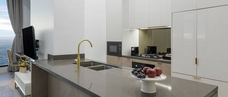 A modern kitchen with a central island, stainless steel appliances, and a view of the city.