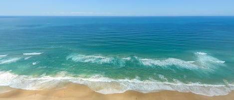 Una playa con agua azul cristalina y una orilla arenosa.