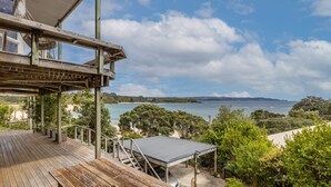 Une terrasse en bois offrant une vue sur une plage et l’océan.