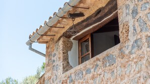 A stone building with a window and a metal gutter.