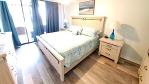 Ein Schlafzimmer mit einem Bett, Nachttischen, einer Lampe und einem Bild an der Wand.