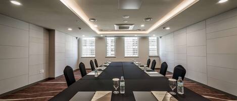 A conference room with a long table, chairs, water bottles, and nameplates.