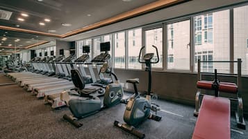 A gym with treadmills, stationary bikes, and a rowing machine.