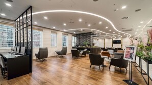 Un moderno vestíbulo de hotel con una recepción, zona de estar y un bar.