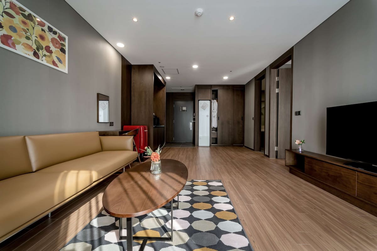 A modern living room with a sofa, a coffee table, and a TV.