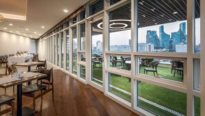Un comedor moderno con ventanas amplias, una mesa larga y sillas.