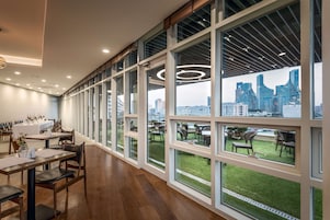 Un comedor moderno con ventanas amplias, una mesa larga y sillas.