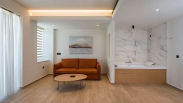 A modern living room with a sofa, coffee table, and a painting on the wall.