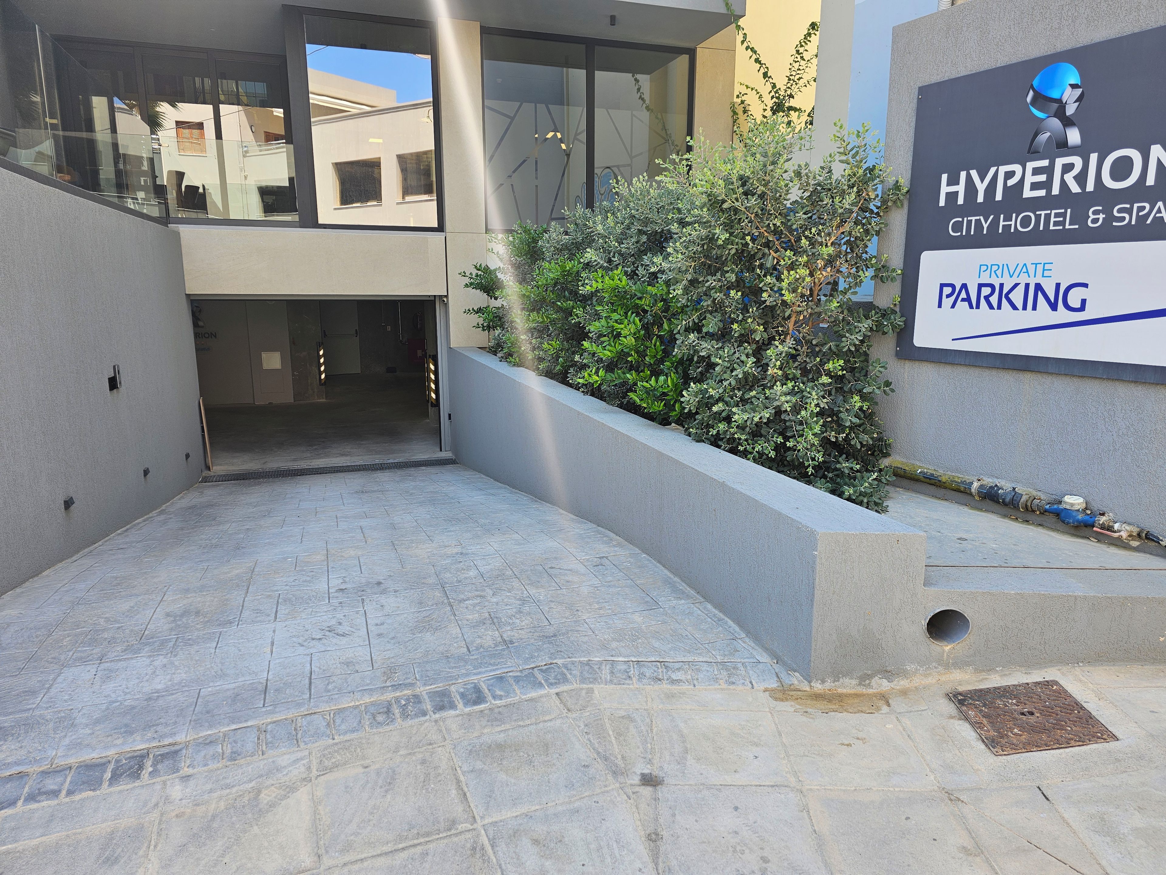 A modern building with a sign for Hyperion City Hotel & Spa, indicating private parking.