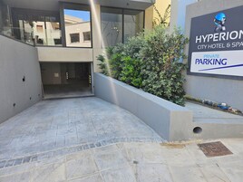 A modern building with a sign for Hyperion City Hotel & Spa, indicating private parking.