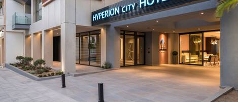L’extérieur de l’hôtel Hyperion City se distingue par sa façade moderne, son grand hall d’entrée vitré et son espace de réception bien éclairé.