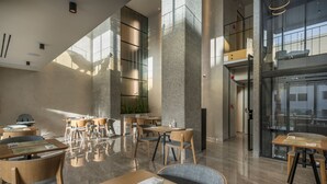 Un interior espacioso y moderno con techos altos, ventanas amplias y una combinación de muebles de madera y tapizados.