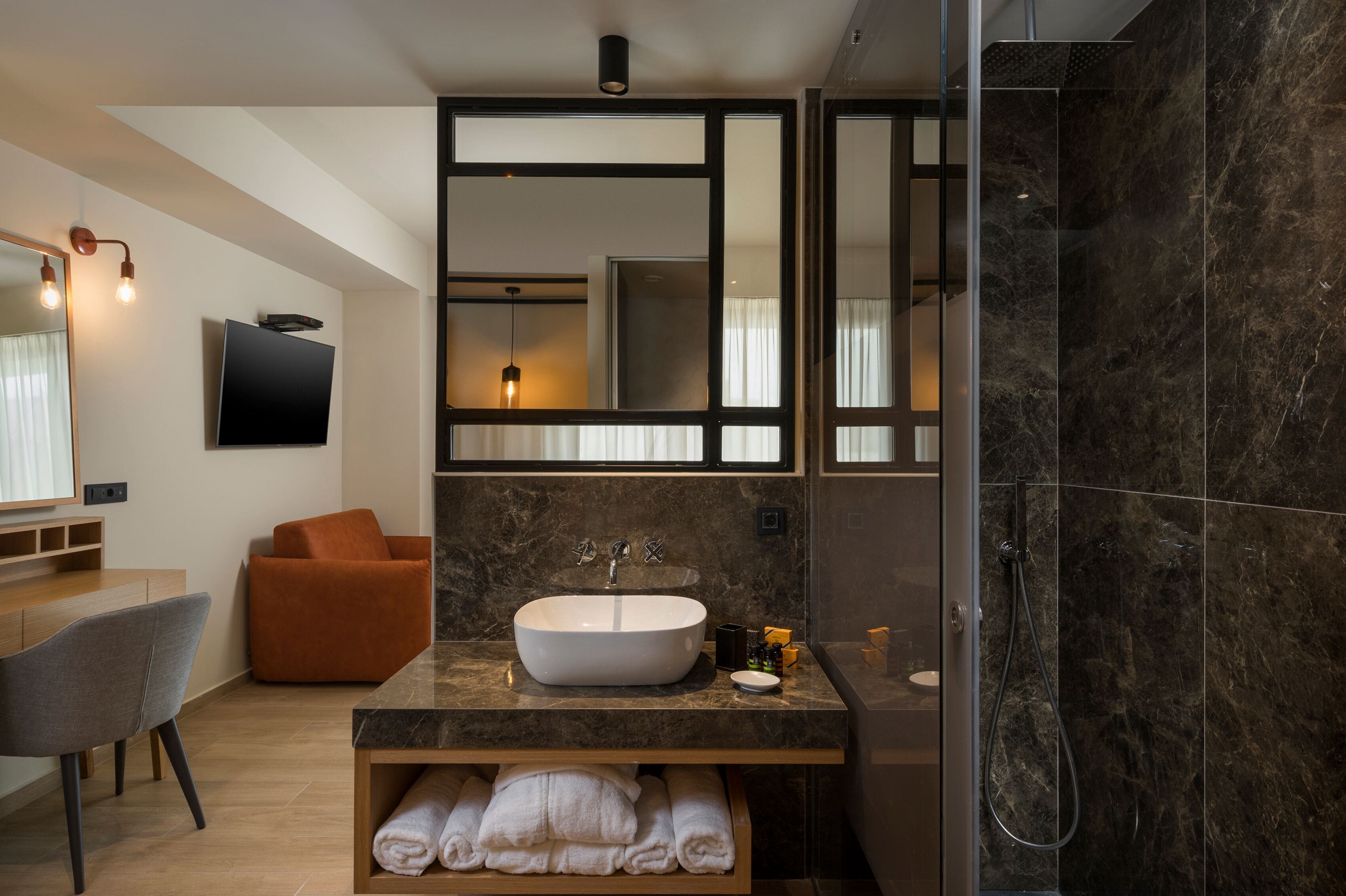 A modern bathroom with a large mirror, a sink, and a shower.