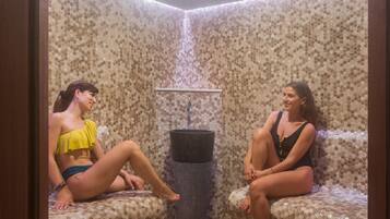 A room with a hexagonal patterned wall, a central sink, and two seating areas.