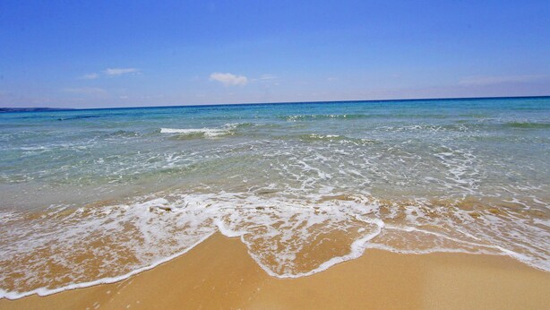 A beach with clear blue water and a sandy shore. - Sea view villa with garden and private hot tub 242 (Marina di Pescoluse)