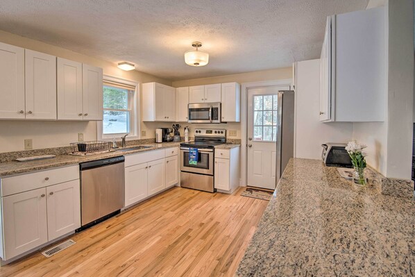 Enjoy cooking in this well-equipped kitchen with a window offering a view of the outdoors.