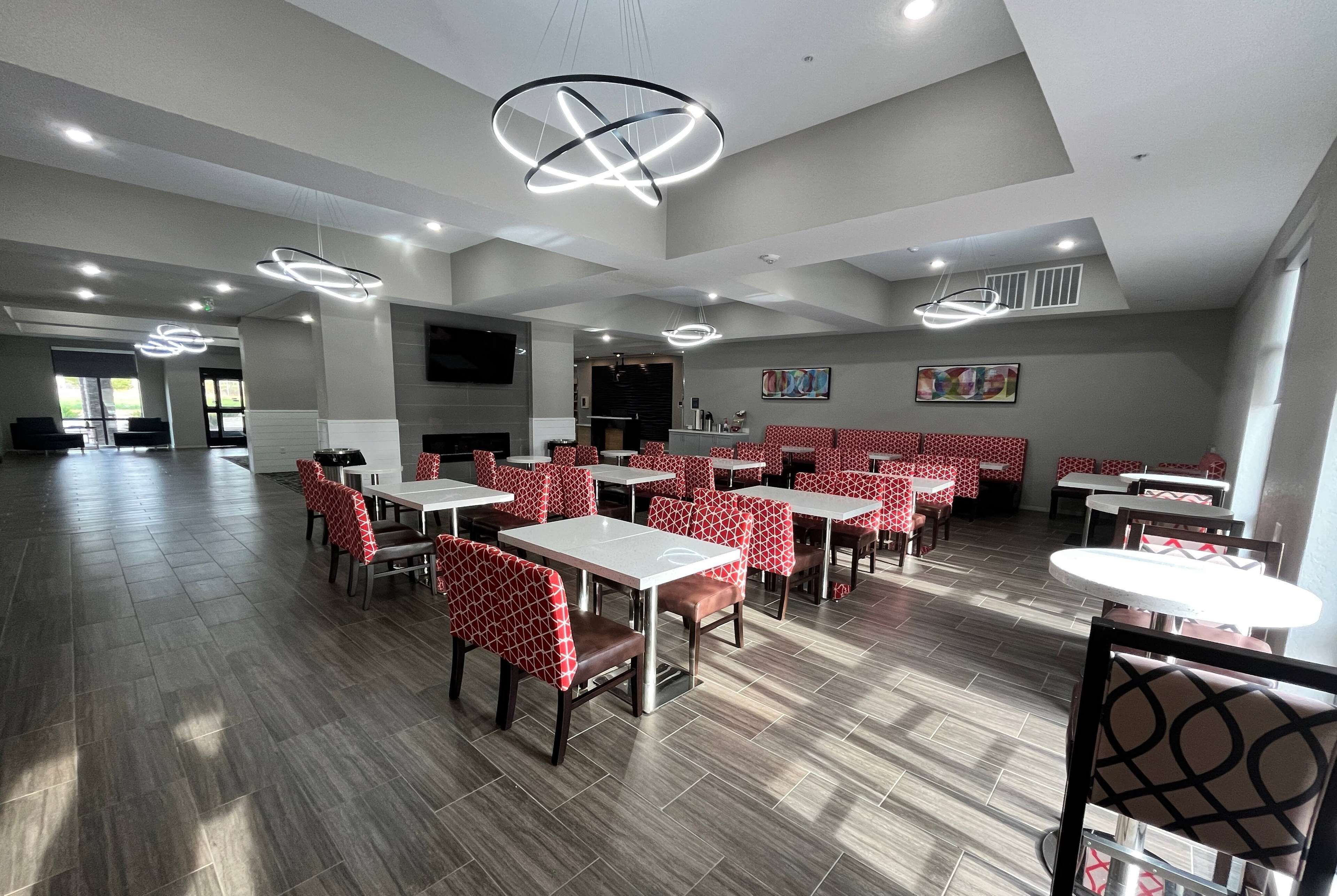Un restaurante espacioso con techos altos, luminarias modernas y una combinación de asientos tipo cabina y mesas.