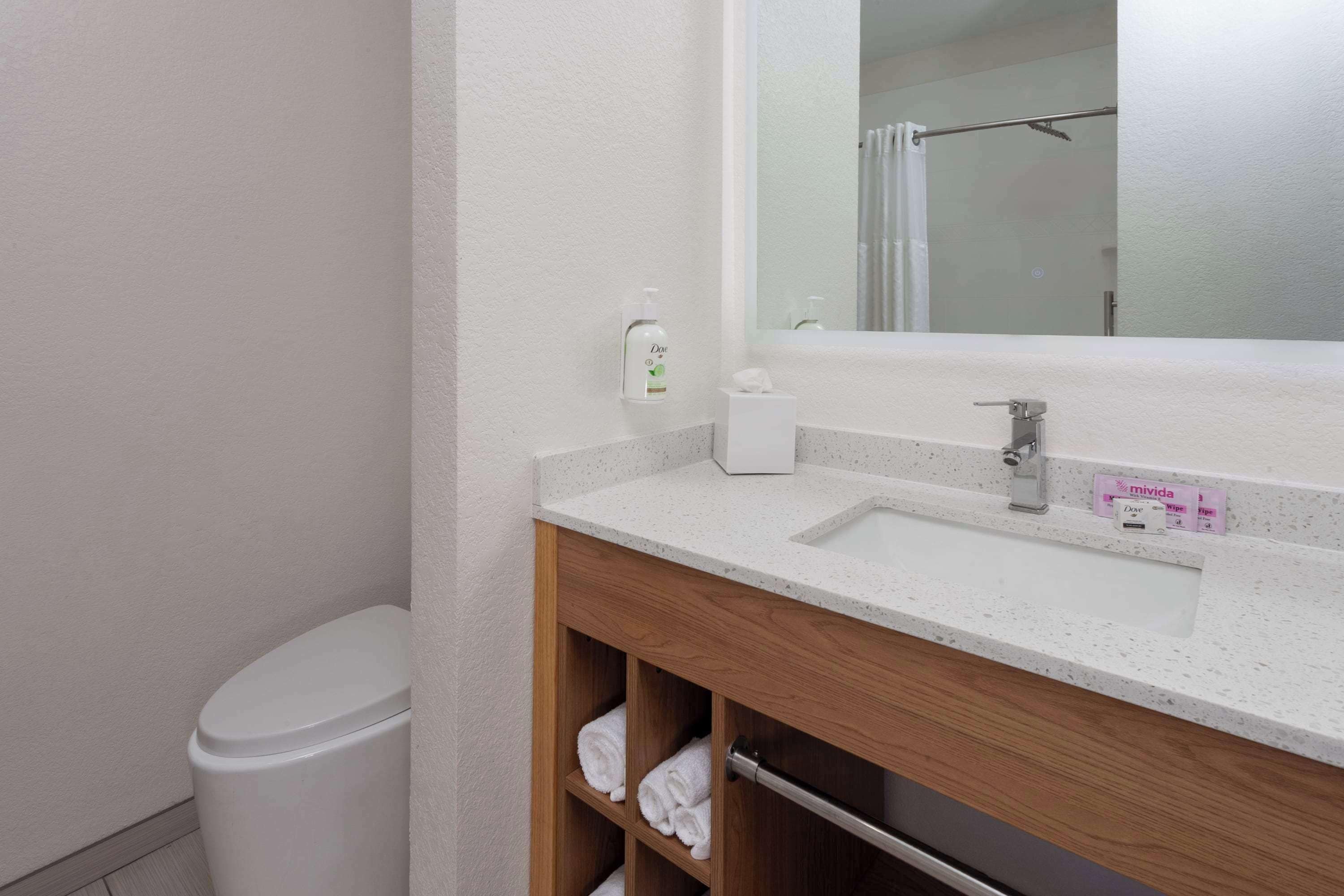 Une salle de bain avec un lavabo blanc, un miroir et une douche.