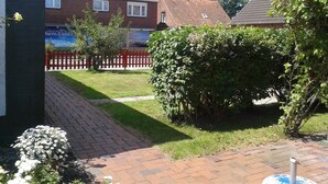 Een woonwijk met huizen, een verhard pad en een rode afrastering.