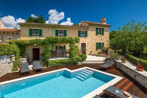 Une villa avec piscine, un espace salon extérieur et un jardin.