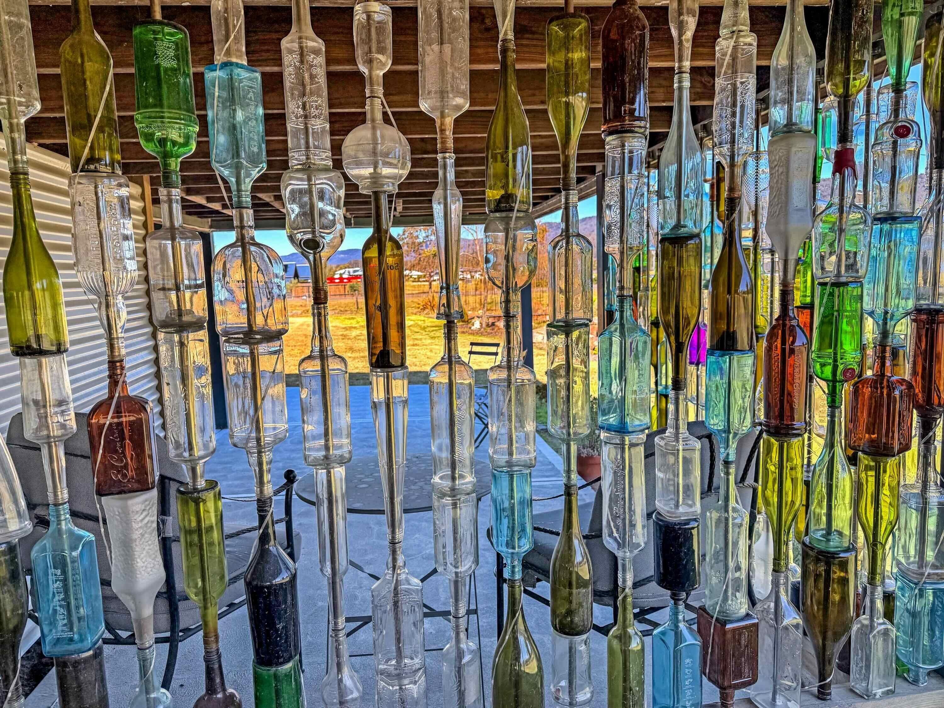 A collection of various glass bottles displayed vertically on a table.