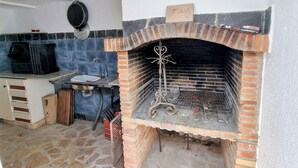 Una cocina con un horno de ladrillo, un lavamanos y una placa con nombre.