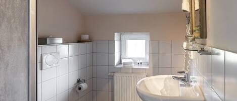 Un baño moderno con inodoro, lavabo y ventana.