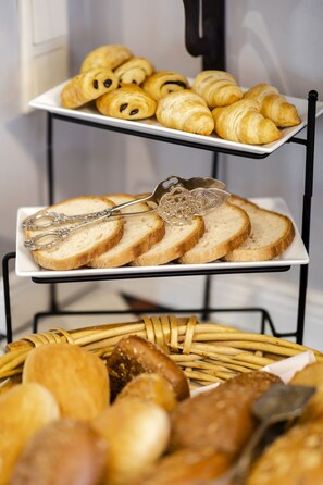 A tray of croissants and a basket of assorted bread.