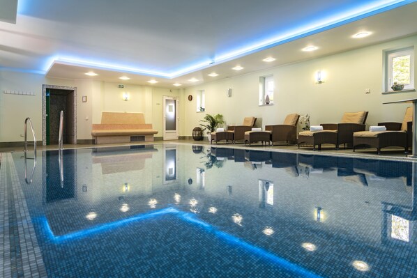 Una piscina cubierta, tumbonas