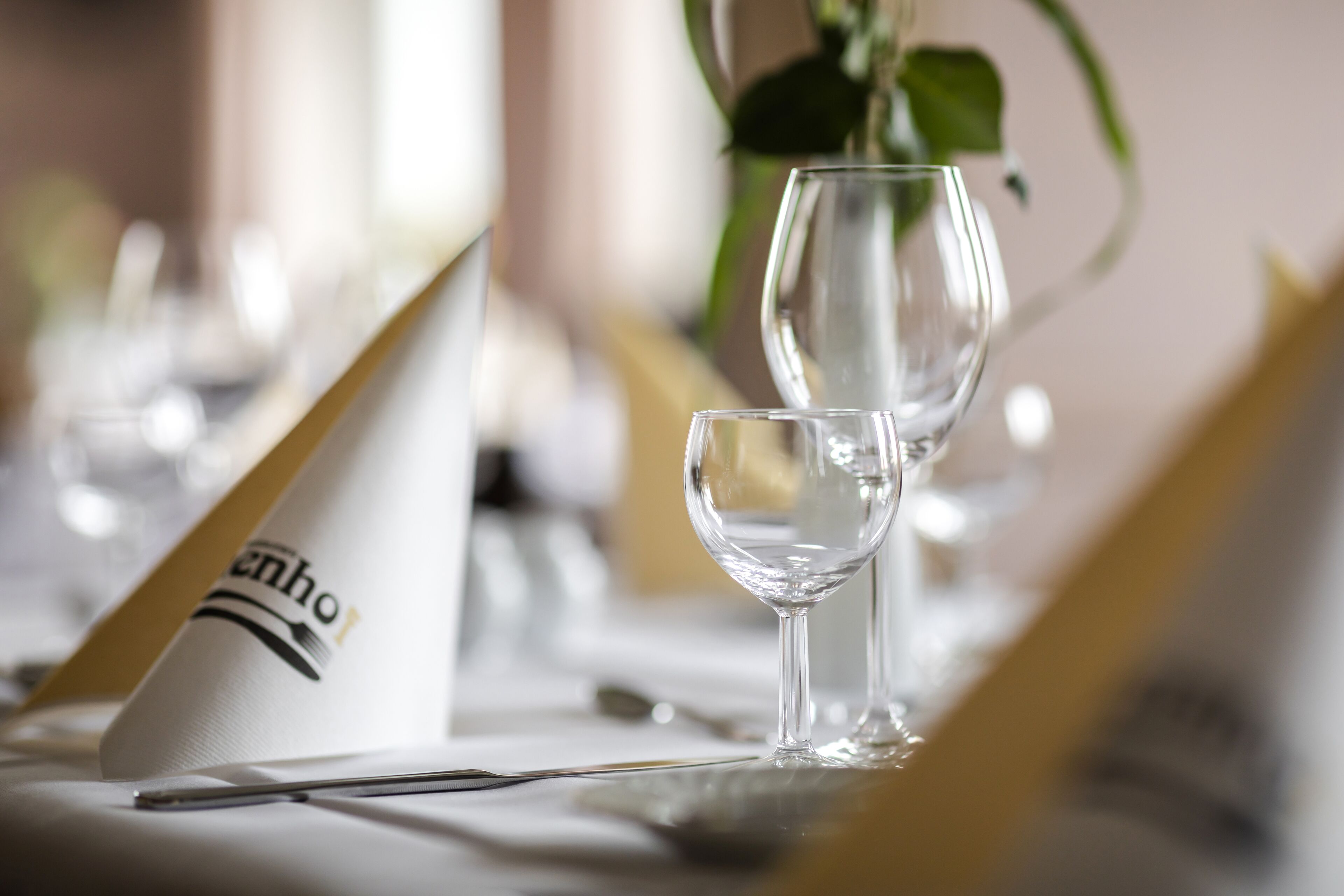Una mesa dispuesta con una copa de vino, una servilleta y una carta.