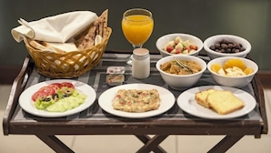 A breakfast tray with various food items including toast, a salad, a bowl of fruit, and a glass of orange juice. - Hotel One Sukkur (Sukkur)
