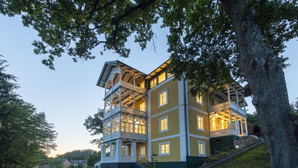 A multi-story building with balconies and a staircase leading to the entrance. - Apartment Blue (Pörtschach)
