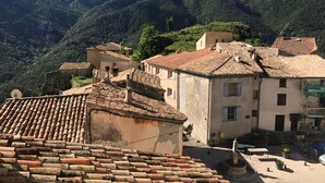 Ein traditionelles Dorf mit terrakotta-gedeckten Häusern und einer bergigen Kulisse.