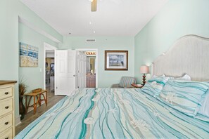 Um quarto com uma cama grande, uma mesa de cabeceira, uma luminária e um quadro na parede.