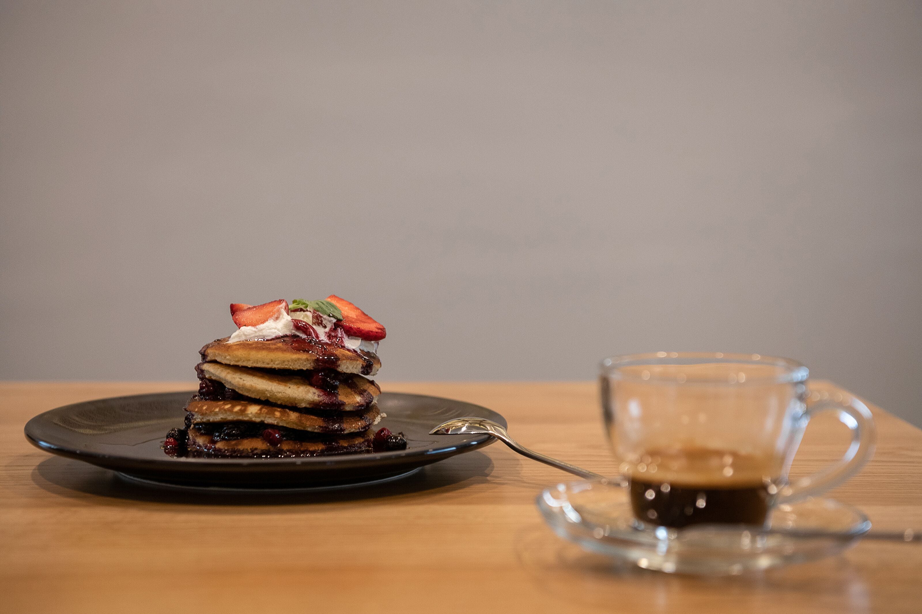 A dessert on a plate with a cup of coffee beside it.