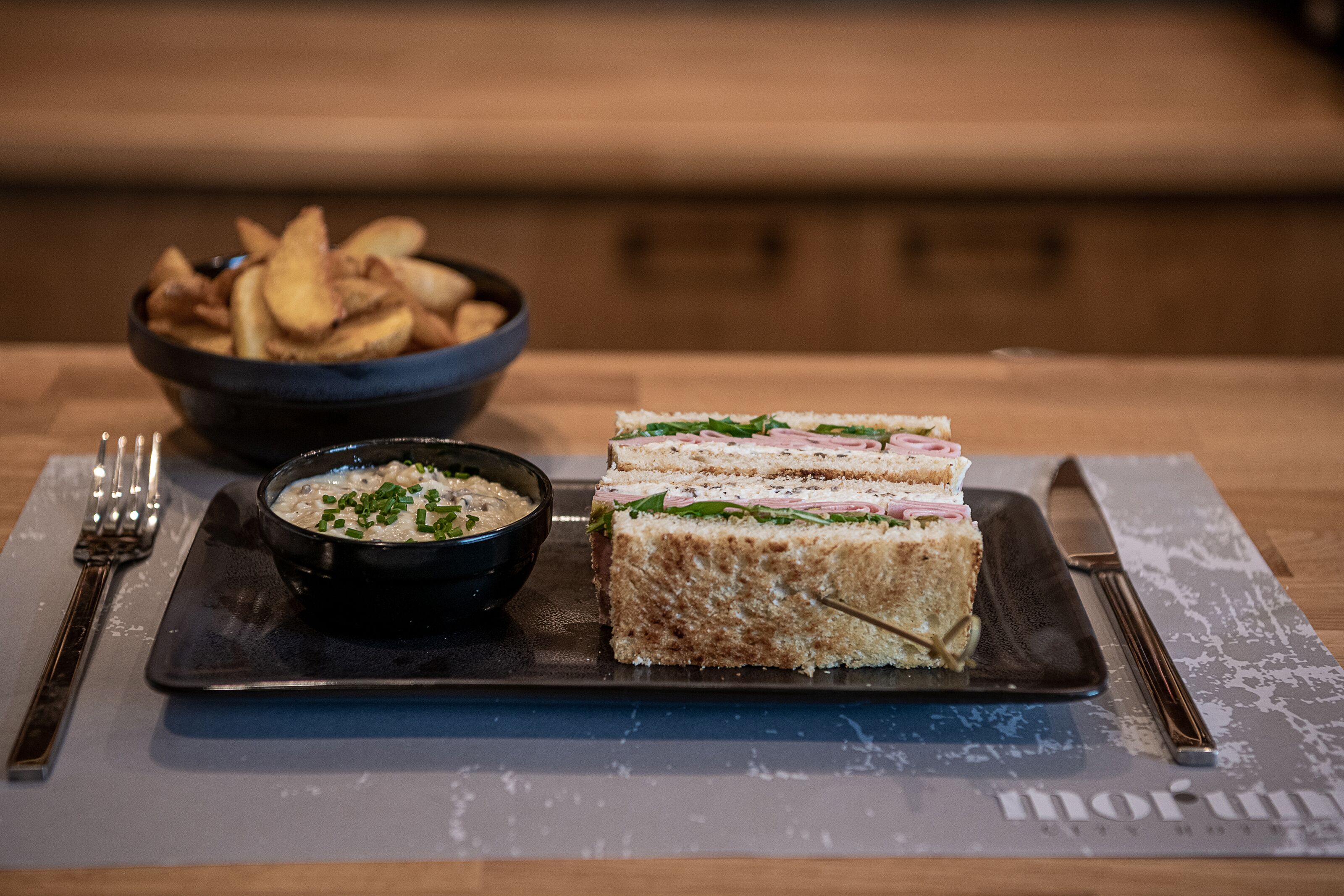 A plate with a sandwich and a bowl of soup on a table.