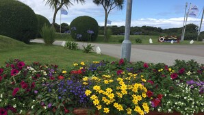 Un jardín ajardinado con una variedad de flores coloridas y arbustos cuidadosamente podados.
