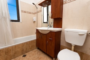 A bathroom with a bathtub, a sink, and a toilet.